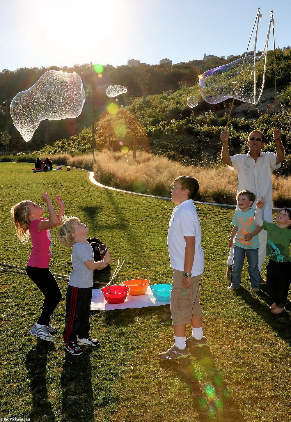 Katie, Charlie and Ryan backlit with big bubbles
