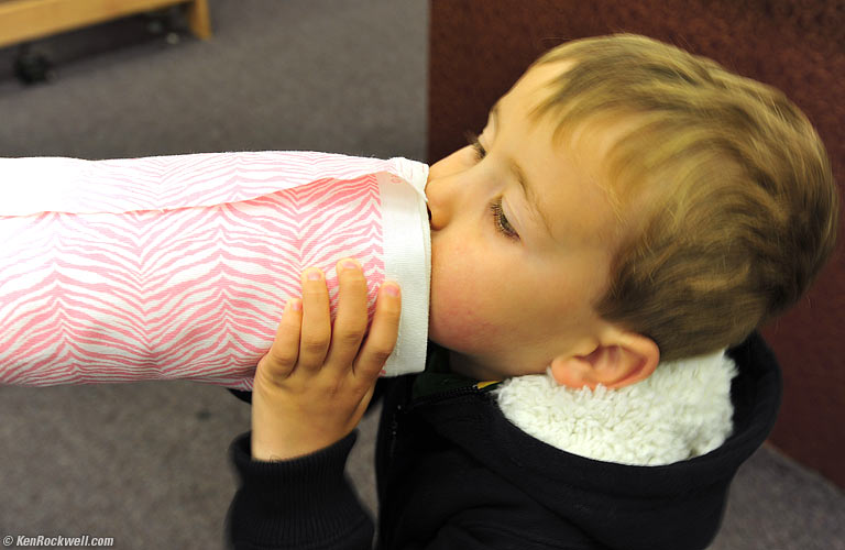 Ryan playing a cardboard tube as if it's a brass instrument, as Daddy taught him