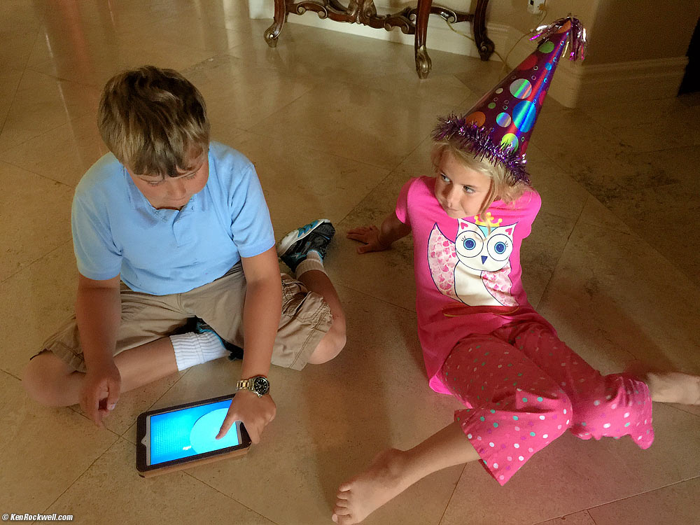 Ryan plays with Ollie on my iPad Mini while Katie looks on in a party hat