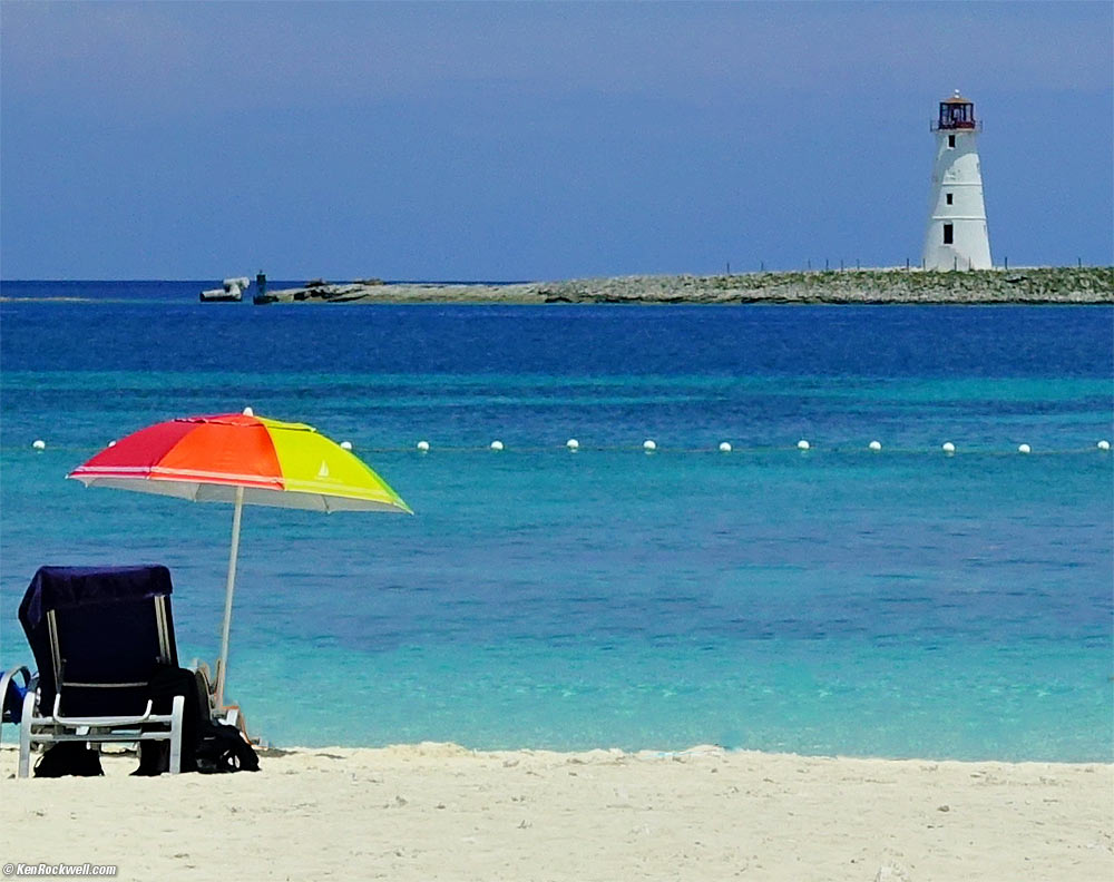 Beach, umbrella and lighthouse, Nassau, Bahamas
