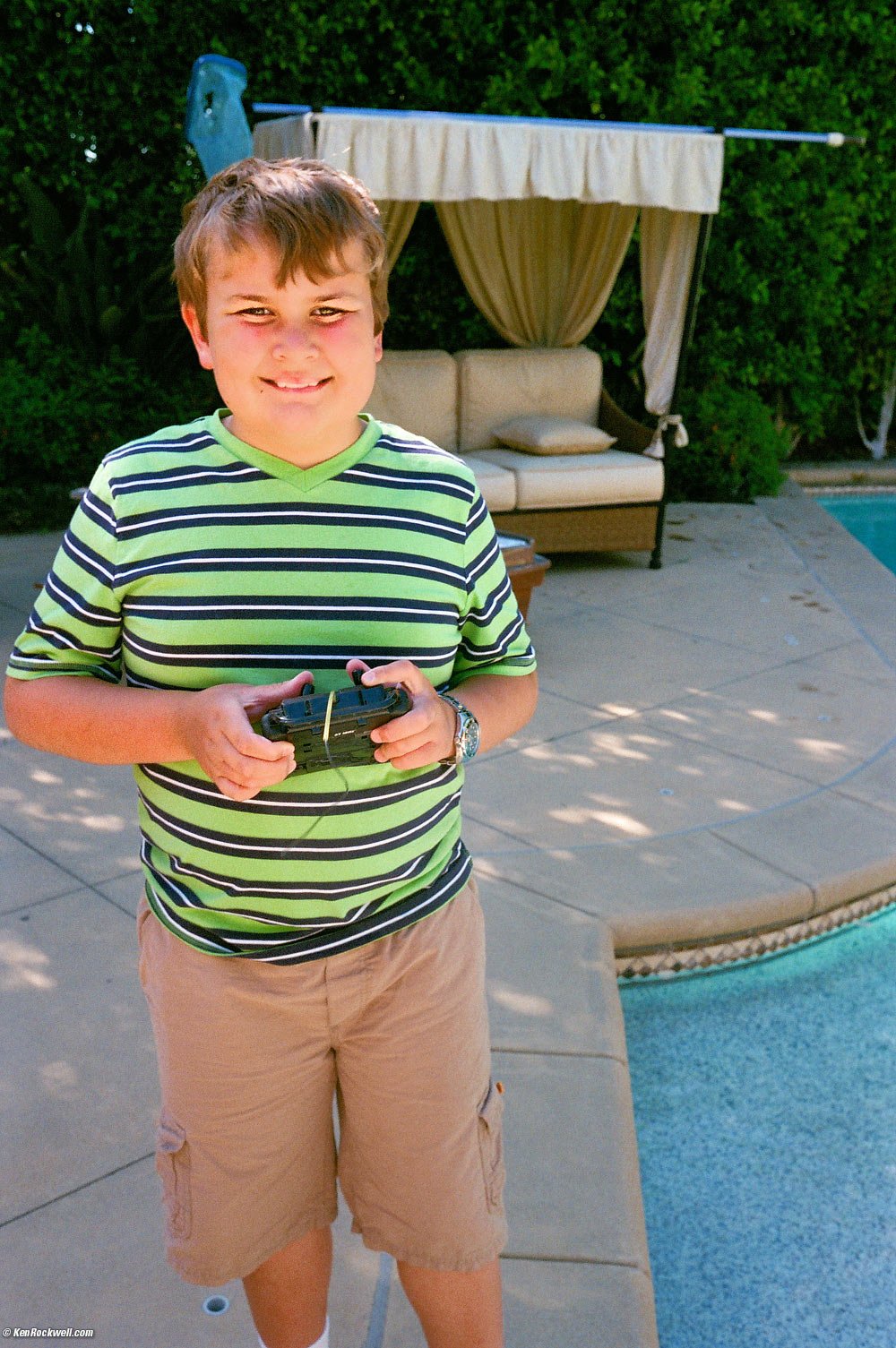Ryan by the pool with the remote control transmitter for his boat.