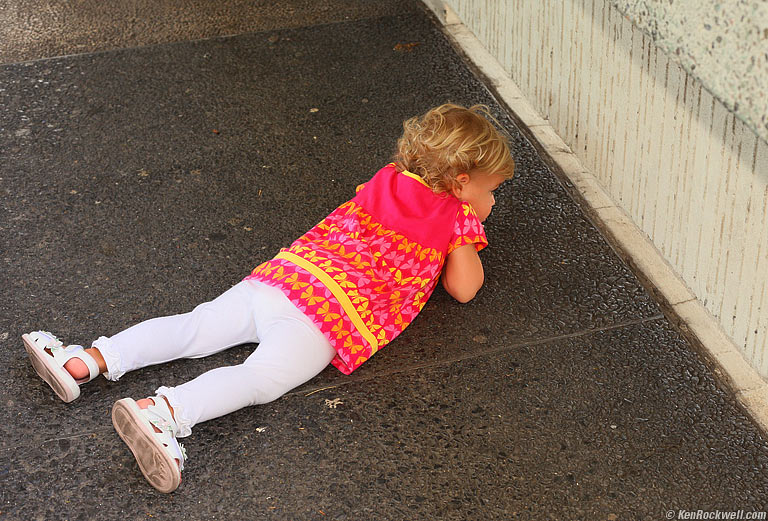 Katie looking under the concrete fence, Honolulu. 11:33 AM.